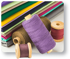 Fabric rolls and sewing threads representing material sourcing and fabric development